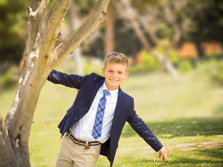 fresh portrait of a boy dressed in a suit and tie in a park © sanedor