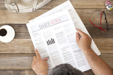 Naklejka premium reading newspaper at morning