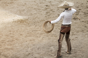 Mexican charro performing a trick with is lasso