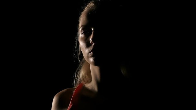 Slow motion of boxer portrait. Young white woman in black background. Fighting sport fitness concept.