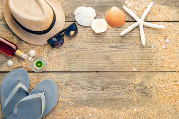Fototapeta na wymiar Summer hat, shells, sun glasses, tanning oil and flip flops with copy space