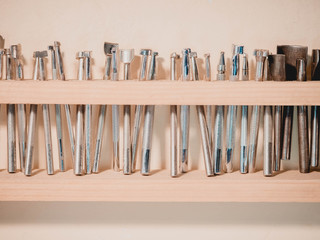 Carving stamps set tool on the shelf. Leather craft instruments for processing of natural materials