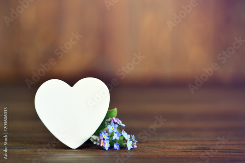 Mothers Day card with heart and flowers on wooden background