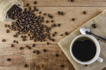 Coffee cup and beans on wooden background