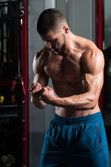 Muscular Man Flexing Muscles In Gym