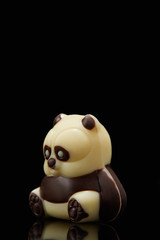 Fototapeta premium closeup shot of panda shaped chocolate on black background