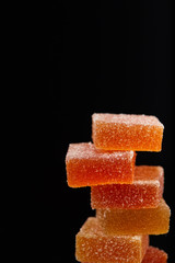 closeup view of stack of jelly candies isolated on black background