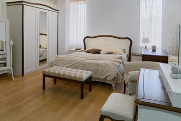Fototapeta na wymiar Light linen on bed in cozy bedroom with mirror