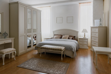 Light linen on bed in elegant bedroom with mirror