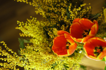 Flower bouquet of red tulips and mimosa. Shooting from the top. Spring mood.