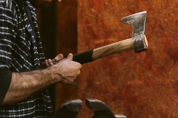 Man working in carpentry workshop. He makes leather winding on wooden ax handle. Men at work. Hand work.