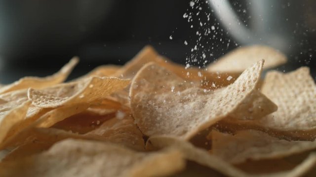 Adding salt on tortilla chips. Shot with high speed camera, phantom flex 4K. Slow Motion.