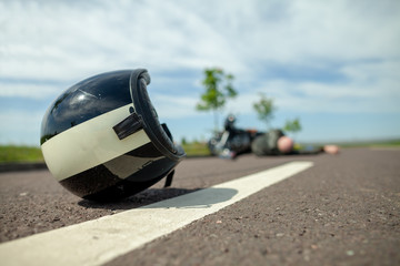 Obraz premium kask motocyklowy leży na ulicy w pobliżu wypadku motocyklowego