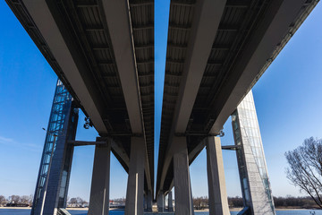 A new bridge of two parts made of concrete and metal over a wide river to pass traffic from the big city