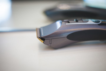 Hair clipper in black colour put on white desk. 