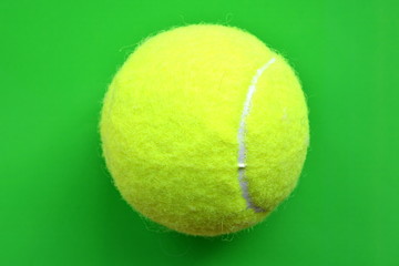 yellow tennis ball on bright green background