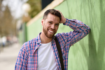 Attractive young man laughing outdoors. Lifestyle concept.