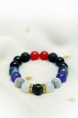 
Colorful spectrum lucky stone bracelet bead on white towel background.fashion with believe in Add...