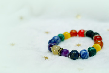 
Colorful spectrum lucky stone bracelet bead on white towel background.fashion with believe in Add...