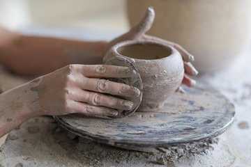 potter sculpts a vase on a potter's wheel