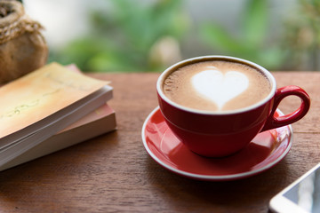 Red cup of coffee with latte art heart shape,soft focus design for valentine background