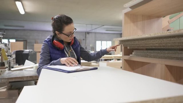 Woman working in wood industry checking stock