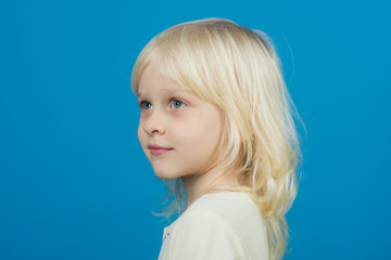 Little girl with young tender skin. little girl with blonde hair on blue backdrop.