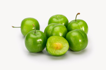 Close Up Of Green Plums Or Greengage showing the flesh and the seed of the fruit Isolated On White Background, Popular Spring Fruits With A Very Sharp Sour Taste Originated In Iran
