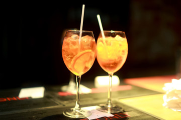 Two cocktails with orange on the bar in the restaurant