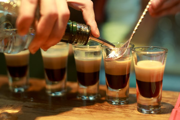 Barman make alcoholic shots with rum and liquor