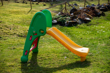 a yellow slide standing i the middle of a garden