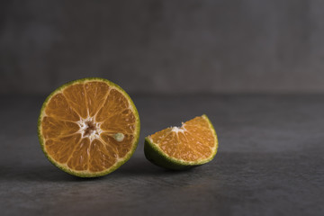 Fresh orange fruits and juice on stone table.