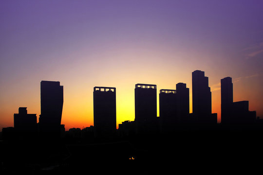 Silhouette image of cityscape on colorful sky background in the evening