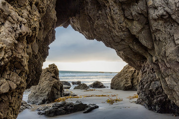 Sunset view through natural arch at Malibu beach in California