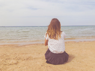 Single woman looking at ocean / sea view.