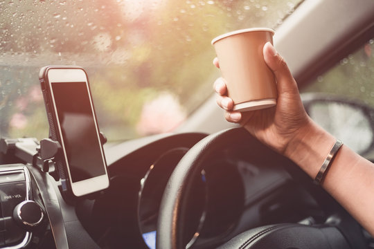 transportation and vehicle concept - driver drinking coffee while driving the car