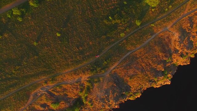Flight upwards over a rocky coast, in the warm rays of the setting sun. Khortitsa Island, the Dnieper River, Ukraine.