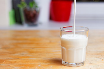 Milk poured into a glass in the kitchen