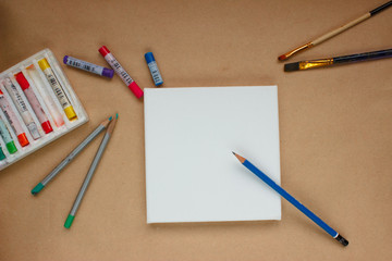 Blank canvas with brushes and pencils