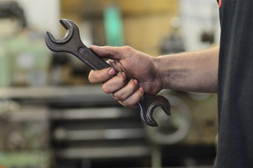 Dirty hand of working man with spanner wrench