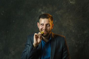 A young businessman holds a coin of bitcoite in his hand.