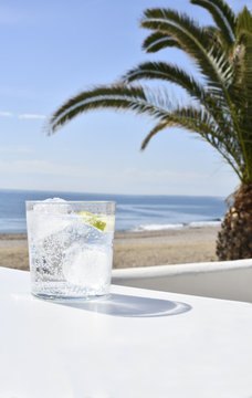 ice drink on a beach, with the sea and sand in the background also a large palm, selective focus, on a white foreground, shot for copy space 