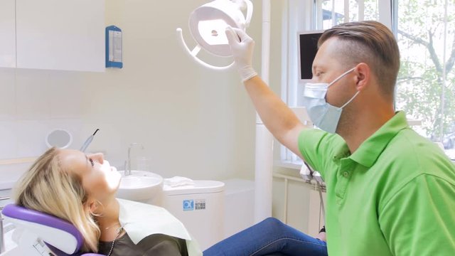 4k footage of dentist turning on lamp and using drill for teeth treatment