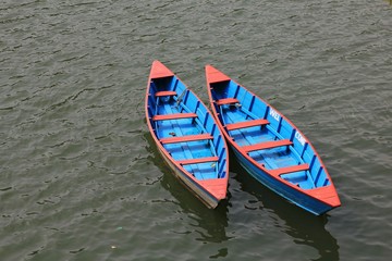 Obraz premium Blue red timber rowing boats on Fewa lake, Pokhara.