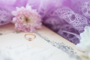 engagement ring. Retro background with old book and chrysanthemums