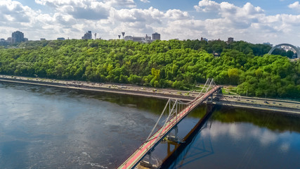 Aerial top view of pedestrian Park bridge, Dnieper river and Kyiv hills from above, city of Kiev, Ukraine
