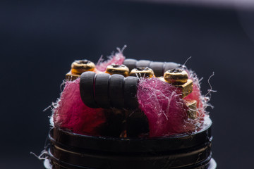 Vape close-up with wet cotton wool on black background