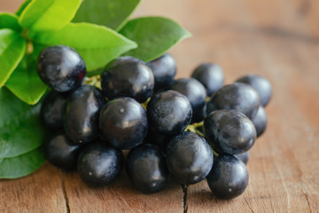 Bunch of fresh seedless red grape on wood table in close up view with copy space for background or wallpaper. Delicious and healthy fruit with sweet taste and juicy suitable for eating and make wine.