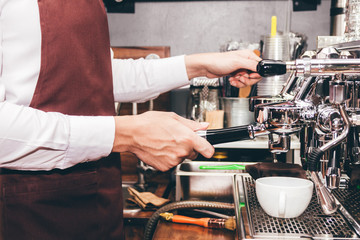 Man Barista using coffee machine for making coffee in the cafe