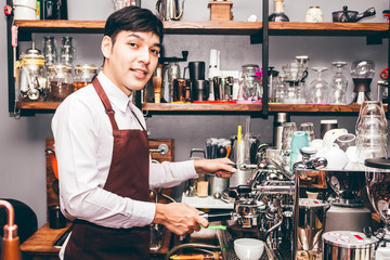 Man Barista using coffee machine for making coffee in the cafe
